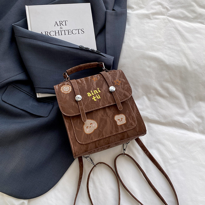 Bolsa universitaria viento rojo para mujeres 2025 nueva moda alta sensación de mochila de viaje universal mochila