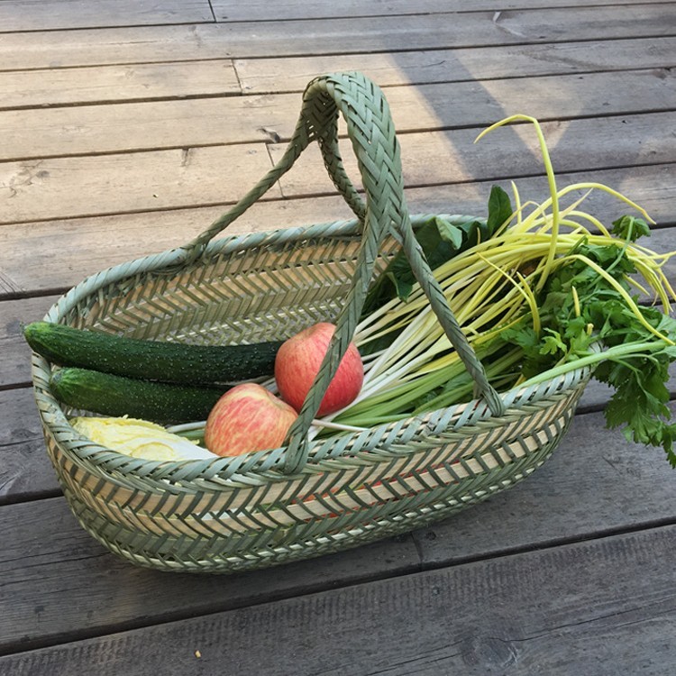 竹編みの竹かごを手に持って野菜かごを買う手作りの竹かごの果物かごの卵かごの台所収納かごの家庭用買い物かご|undefined