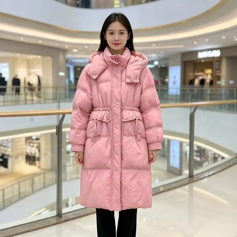 Women's long down jacket for winter, with a fitted waist, slimming effect, hood, large pockets, loose fit, and available in multiple colors Women's long down jacket for winter, with a fitted waist, slimming effect, hood, large pockets, loose fit, and available in multiple colors