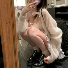霧の少女の柔らかいモチモチとした馬海毛の外に白い薄いカーディガンのニットコートの女性がいます。