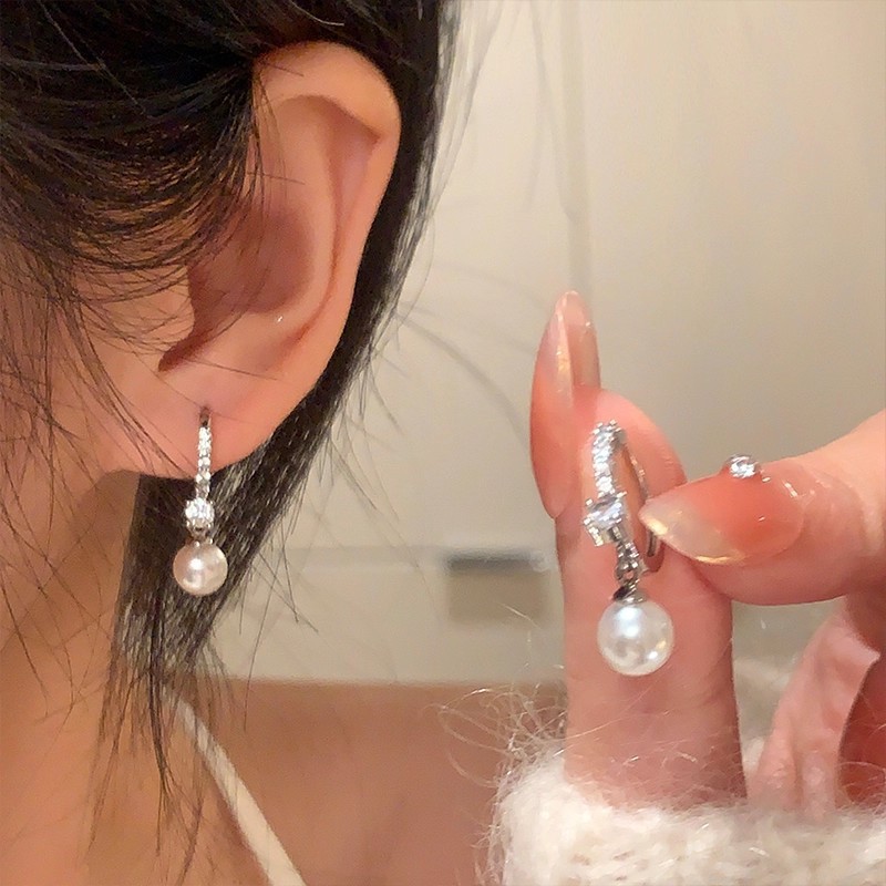 S925 aguja de plata Luz de lujo nicho pendientes de perlas de alto grado versátil elegante exquisito diamante incrustado arco pendientes
