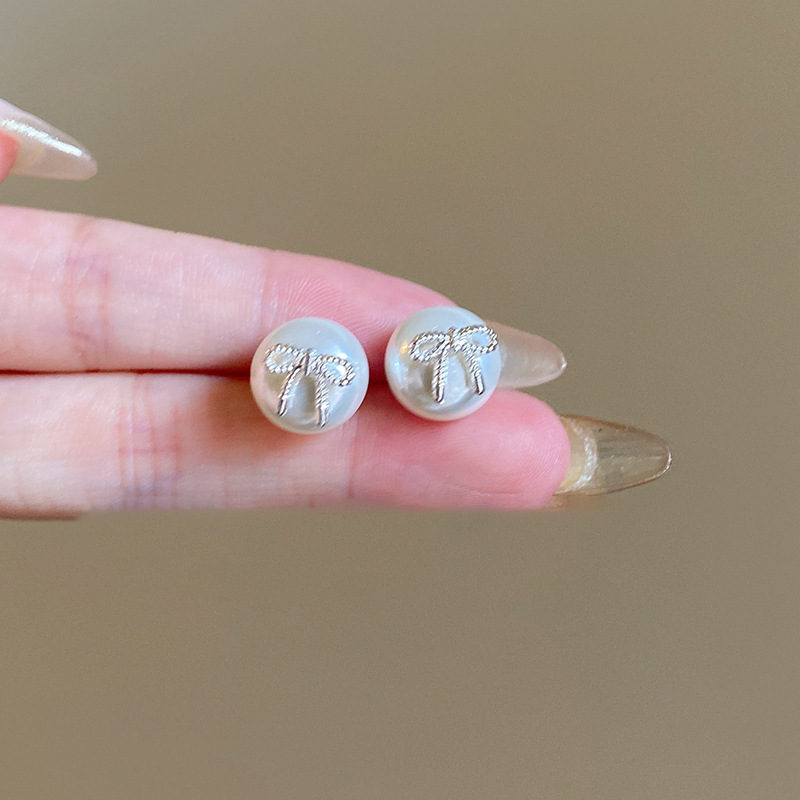 Pendientes de perlas artificiales de mariposa de aguja de plata Pendientes de todo fósforo de nicho retro femenino Pendientes de temperamento de moda Lujo ligero de alta gama
