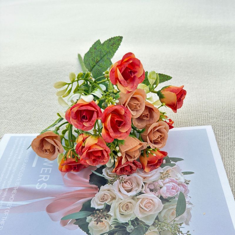 模造花ミニバラは花を手にして家にいる結婚式の室内客間の装飾に造花を飾っている|undefined