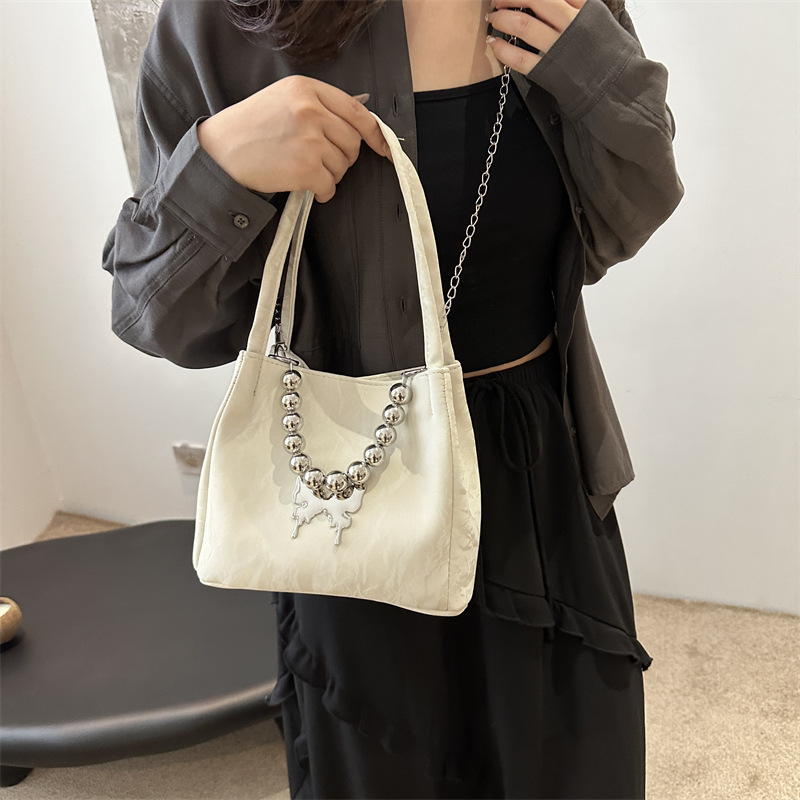 Alta sensación de lujo ligero bolso de cubo axilar 2024 verano nuevo estilo de moda arco de cuentas cadena de hombro mochila