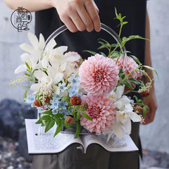 教師の日の本のアクリルの花の花束は花のかごを持って花の箱の手を持って箱の丸い四角形の小さい花の桶を持ちます。