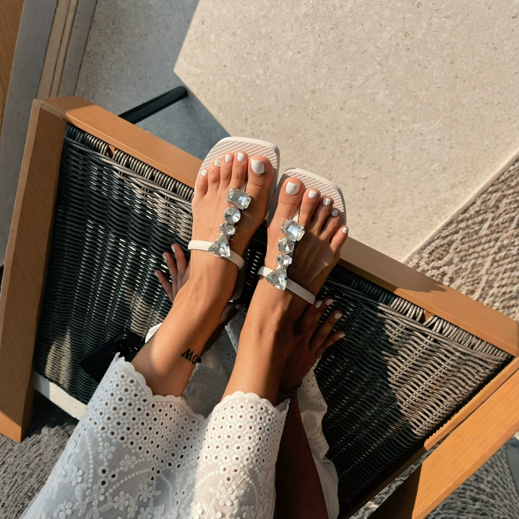 Шляпки для ног 2025 летний новый яркий сверкающий бриллиант плоское дно T-слово с маленькой феей пляжные повседневные тапочки оптом