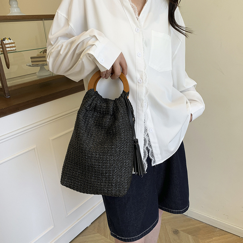 Versión coreana del bolso de cubo de nicho 2025 verano nuevo bolso femenino a rayas bolso de color en contraste bolso tejido con borlas de paja marea