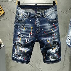 墨をかけて穴を割ったデニムの半ズボンの男性のファッションのブランドを身につけて小さい足を修理します。