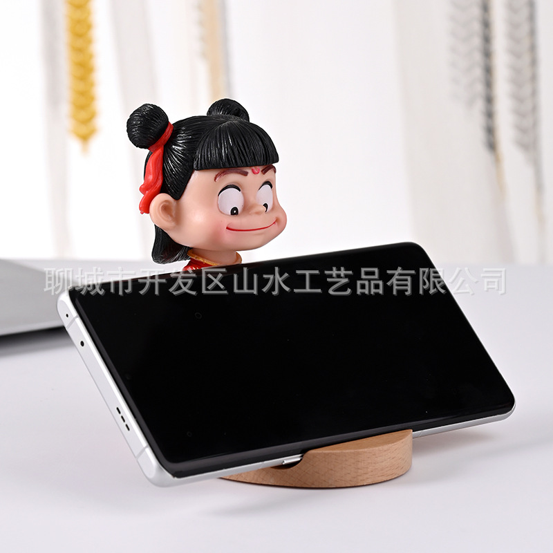 La celebridad de Internet Nezha's Devil Boy Naohai, el soporte para teléfono móvil que rodea el mundo, el soporte para teléfono móvil de madera Nezha Lingzhu, decoración de escritorio