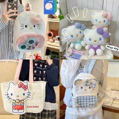 かわいいハローキティの子猫のぬいぐるみが片肩のリュックサックの少女の心を持って街のかわいいランドセルのプレゼントを出します。