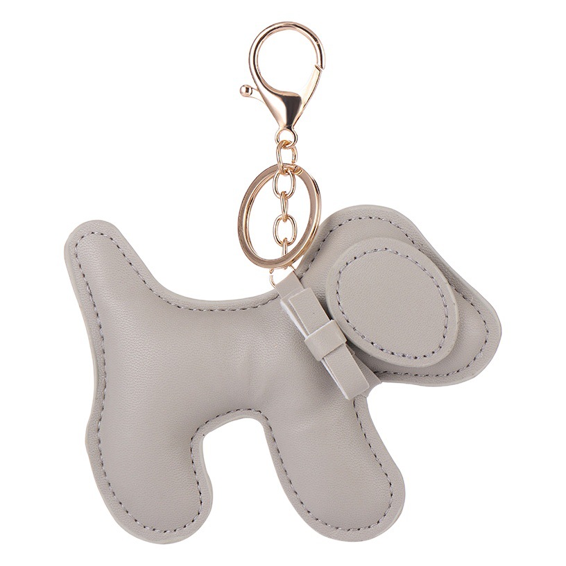 創意的な子犬の鍵は革の掛け物を掛けます。