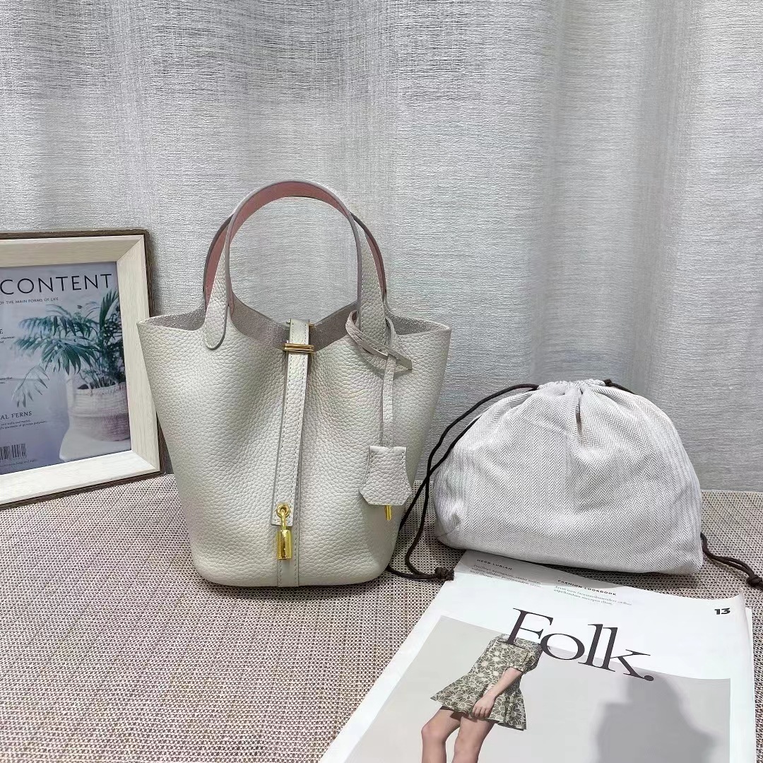 El nuevo bolso de cesta de verduras de marea de cuero togo de piel de vaca de capa superior 2025, bolso de cubo con cerradura de mano, bolso de cuero para mujer