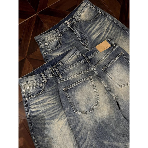 Vintage punk-style straight-leg, low-rise, slightly flared denim trousers with embroidery and a flowing, relaxed fit.