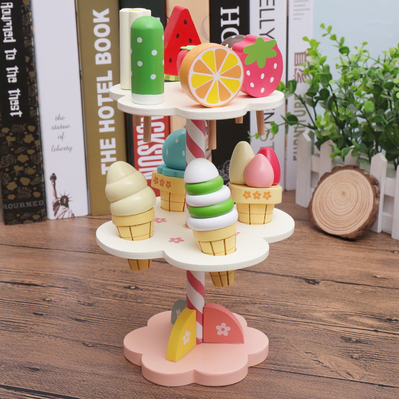 子供の木のおもちゃのままごとは白いアイスクリームの屋台のおもちゃの赤ちゃんの役をシミュレーションします。|undefined