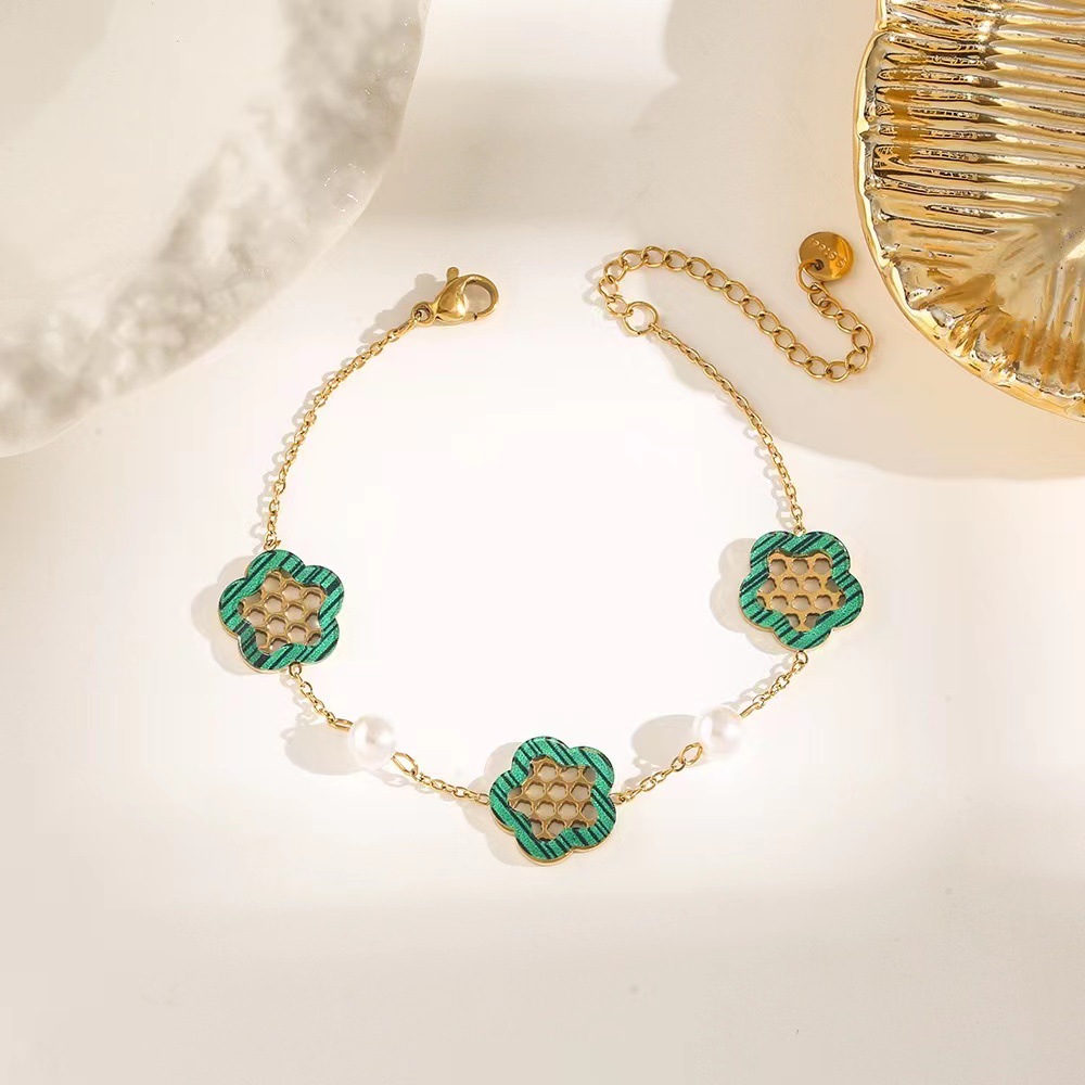Pulsera de trébol de acero titanium vendedora caliente transfronteriza europea y americana con incrustaciones de concha pulsera colgante pulsera de diseño avanzado sin desvanecimiento al por mayor