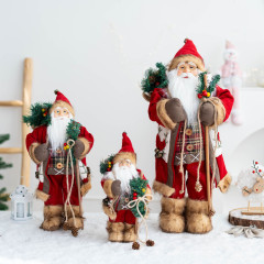 サンタクロースの人形の赤い棒を持っている子供の家のクリスマスの装飾品は立っています。子供の新年のプレゼントです。