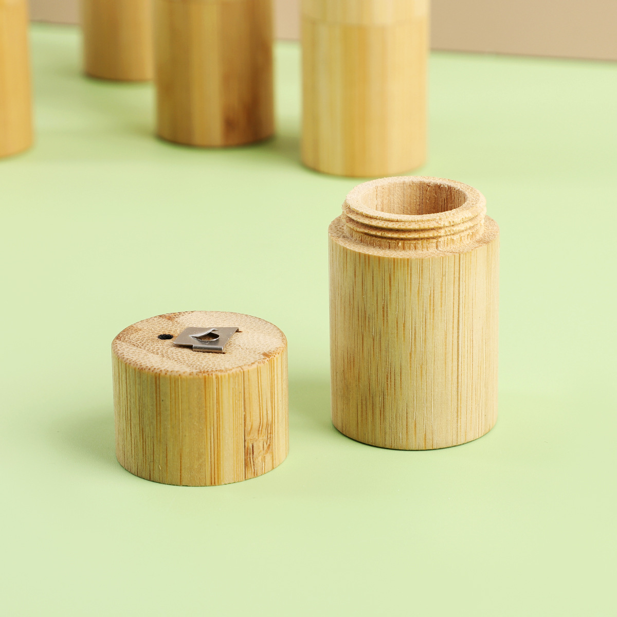 bamboo pencil sharpener with natural wood grain finish and metal blade shown with bamboo floss tube portable biodegradable case