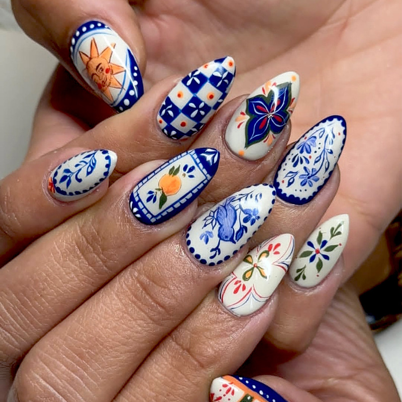 Blue and white branch-patterned short French-style almond-shaped nail tips with floral designs, bow accents, and a whitening effect Blue and white branch-patterned short French-style almond-shaped nail tips with floral designs, bow accents, and a whitening effect