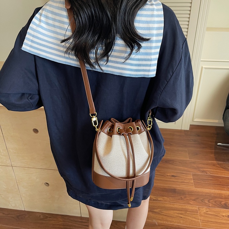 Bolso de lona retro para mujer 2025 nuevo bolso de cubo de diseño de nicho bolso de mensajero de un solo hombro simple y versátil