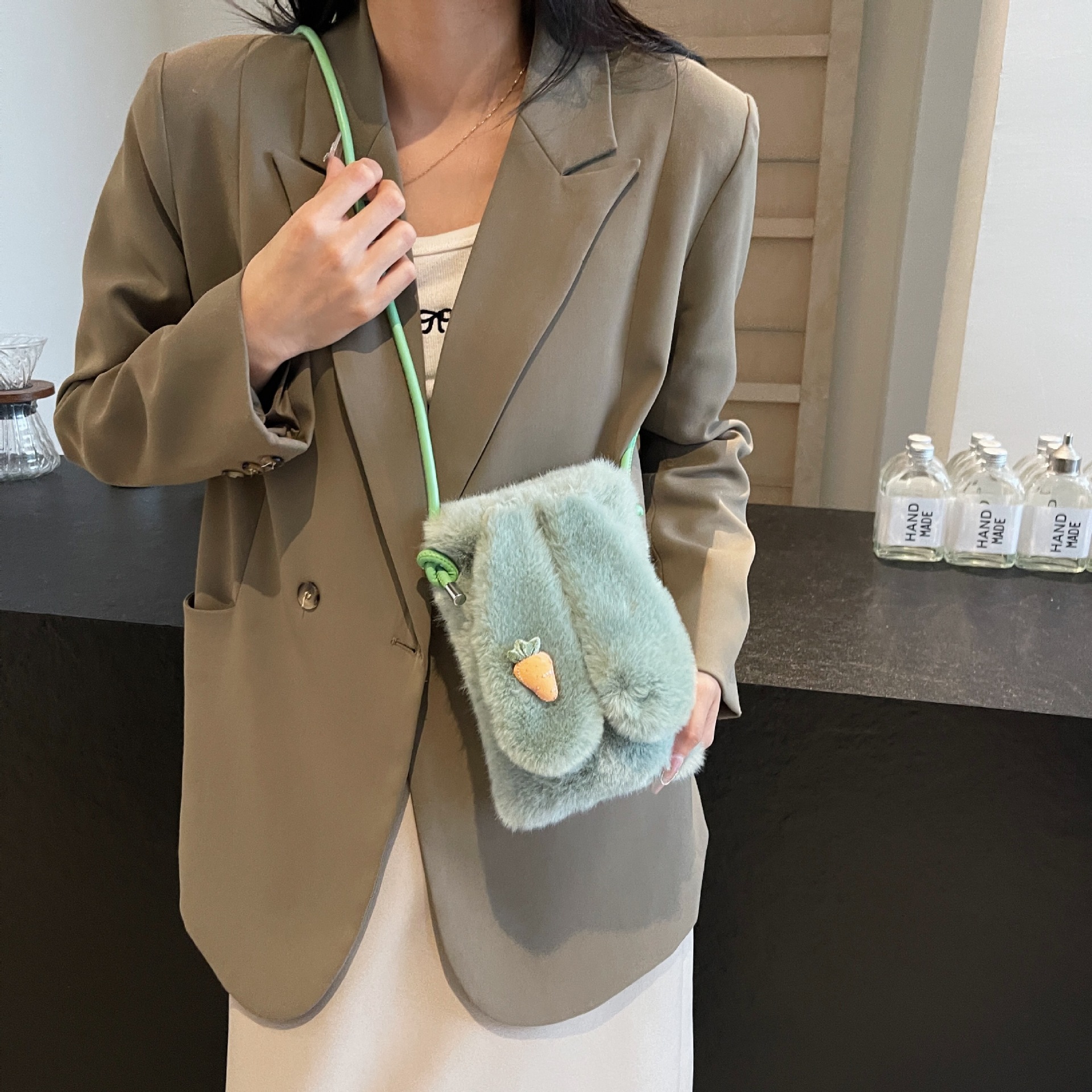 El bolso de teléfono móvil de nicho popular transfronterizo 2025 imita la moda del visón, con un bolso de pelo de oreja de conejo en un hombro.