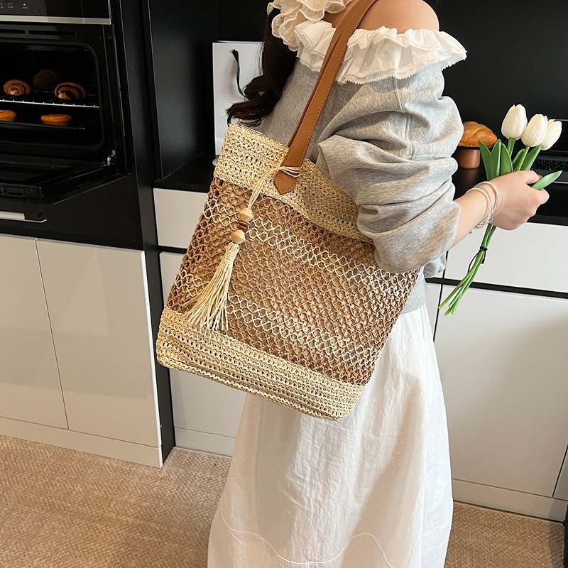 2025 nuevo bolso de cubo portátil de tendencia a cuadros, bolso de paja hueco de vacaciones junto al mar, bolso de hombro de playa de gran capacidad