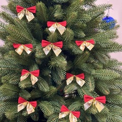 国境を越えてクリスマスを飾ってクリスマスの雰囲気を飾るクリスマスツリーは赤い蝶ネクタイで卸売りを飾っている