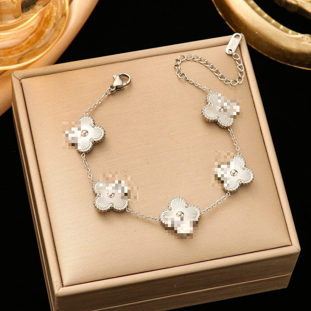 Pulsera de trébol de acero titanium vendedora caliente transfronteriza europea y americana con incrustaciones de concha pulsera colgante pulsera de diseño avanzado sin desvanecimiento al por mayor