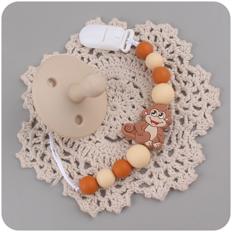 Nuevos suministros para bebés mono de dibujos animados mordedura de chupete de silicona lindo bebé creativo cadena anti-gota cadena