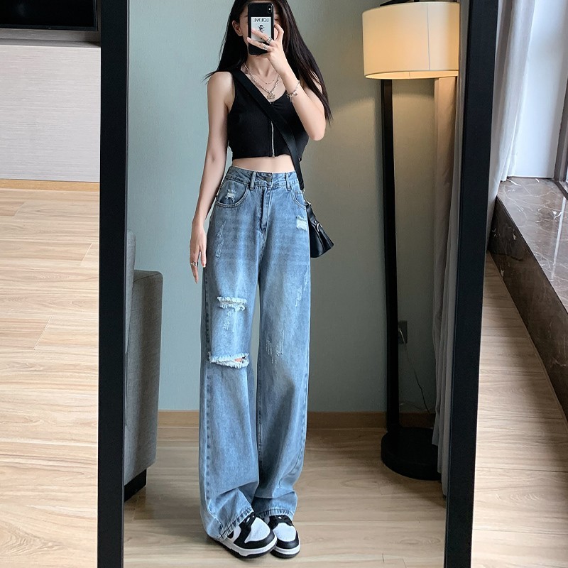 やせて穴が開いているジーンズの女性は腰が高くてゆったりしています。|undefined
