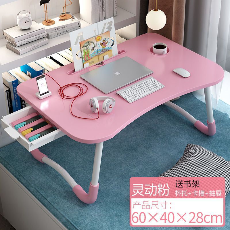 ベッドの上の机の折り畳みの小さい机は引き出しを持っています。|undefined