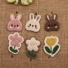 アニメのかわいいぬいぐるみのウサギのタオルは花を刺繍します。