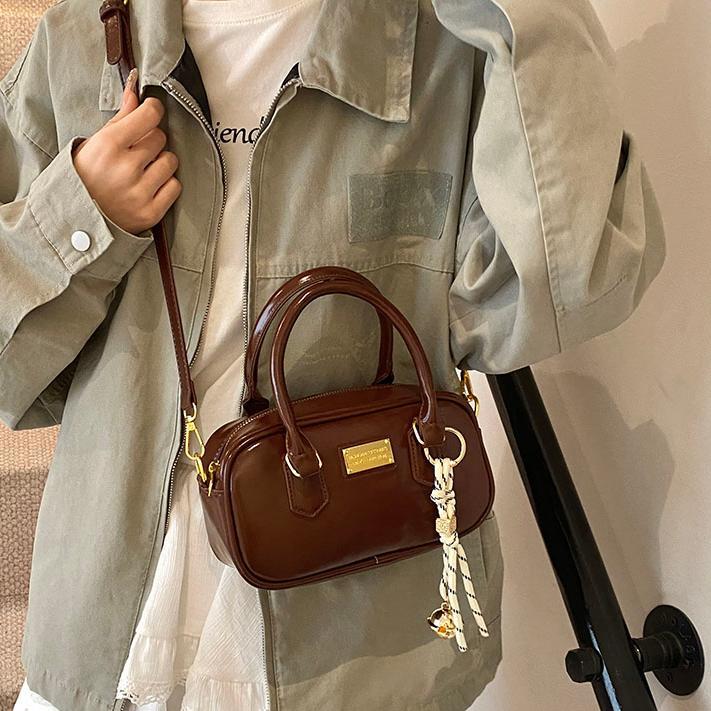 Bolsa de bolos de mano caliente para mujeres 2025, nueva bolsa de hombro simple de moda popular, bolso de mochila de estilo extranjero