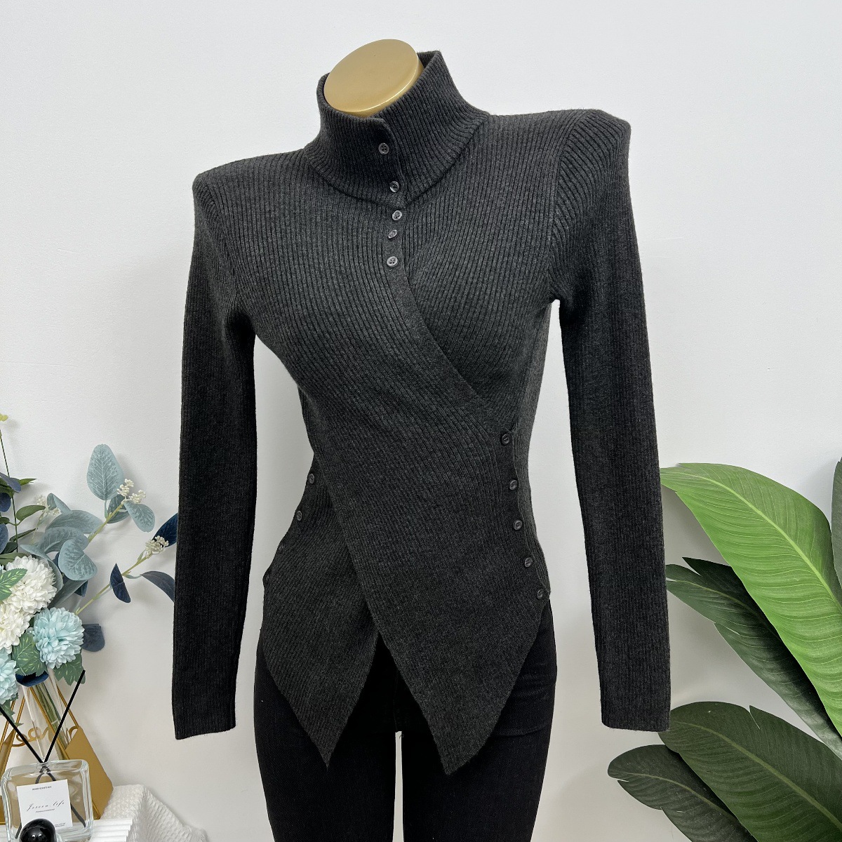 腰を絞めて胸を見せます厚手の高襟秋冬タイプの不規則なスタイルの上着の中にニットの底のシャツの女性2025を掛けます。