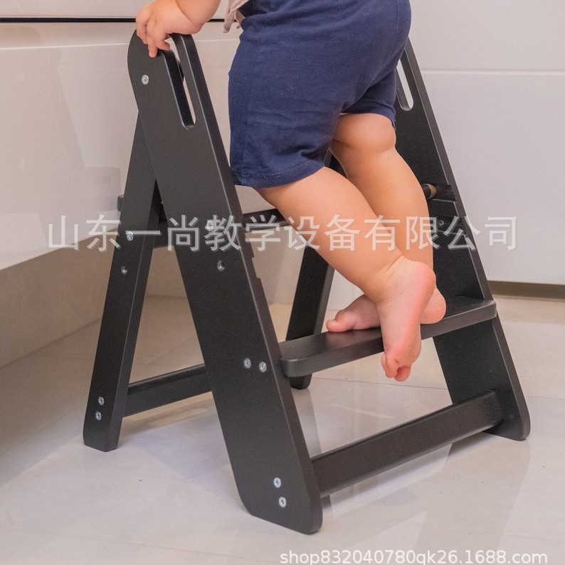 子供の手を洗う腰掛けの赤ちゃんの足は腰掛けを踏みます。