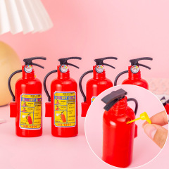 夏の消火器の小さい水鉄砲の子供は水鉄砲を掛けて水遊びをします。