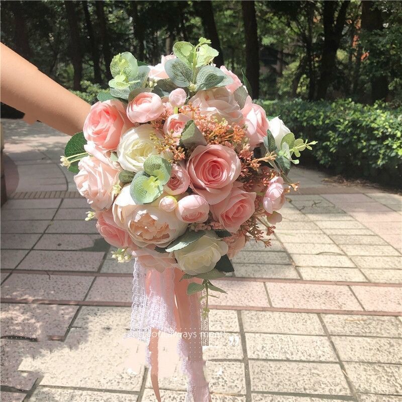 手に花を持つ新婦の韓国式結婚式の領収書のシミュレーションの花束の森系のウェディングドレスの撮影の道具の手に花をささげます。|undefined
