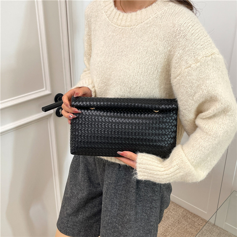 2025 otoño popular trenzado PU bolsos de muñeca bolsos de moda simple bolsos de maquillaje de gran capacidad coreana