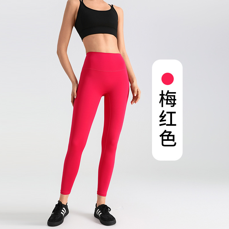 ヨガのズボンの女性は腹を収めて尻を持ちます。|undefined