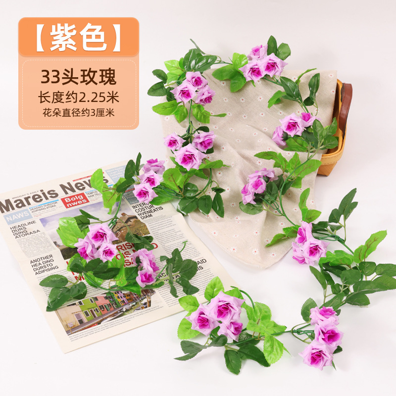 Simulación de flores falsas rosas de caña colgando la pared tubería de drenaje envuelta hoja verde que cubre la parte superior de la decoración de boda de plástico