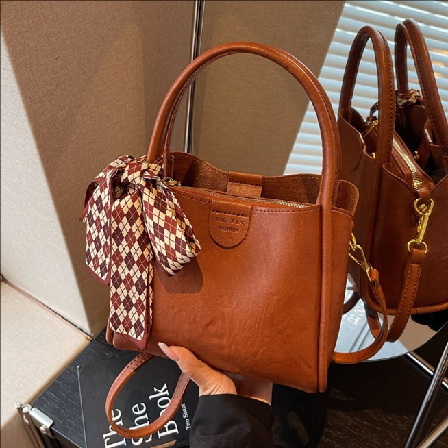 Bagos de transporte retro de estilo extranjero otoño y invierno 2025, nueva moda de un solo hombro, bolsas de cubo simples