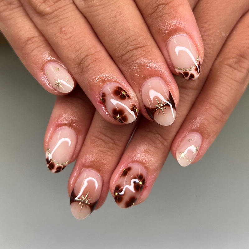 Medium oval nails with brown flowers, French style, gold star accents, European and American style press-on nails, trendy autumn and winter fake nails Medium oval nails with brown flowers, French style, gold star accents, European and American style press-on nails, trendy autumn and winter fake nails