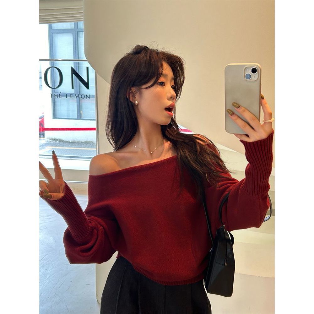 柔らかいピンクの不規則な長袖の斜めの肩のセーターの女性の秋冬の新型の修身の美しい露肩のchiのニットの上着