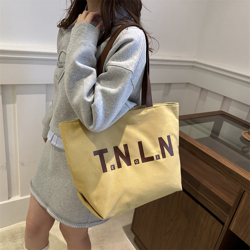 Bolsa de lona de gran capacidad para mujeres otoño / invierno 2024 nuevo estilo coreano letras impresión bolso especial de nicho de viaje bolso de hombro