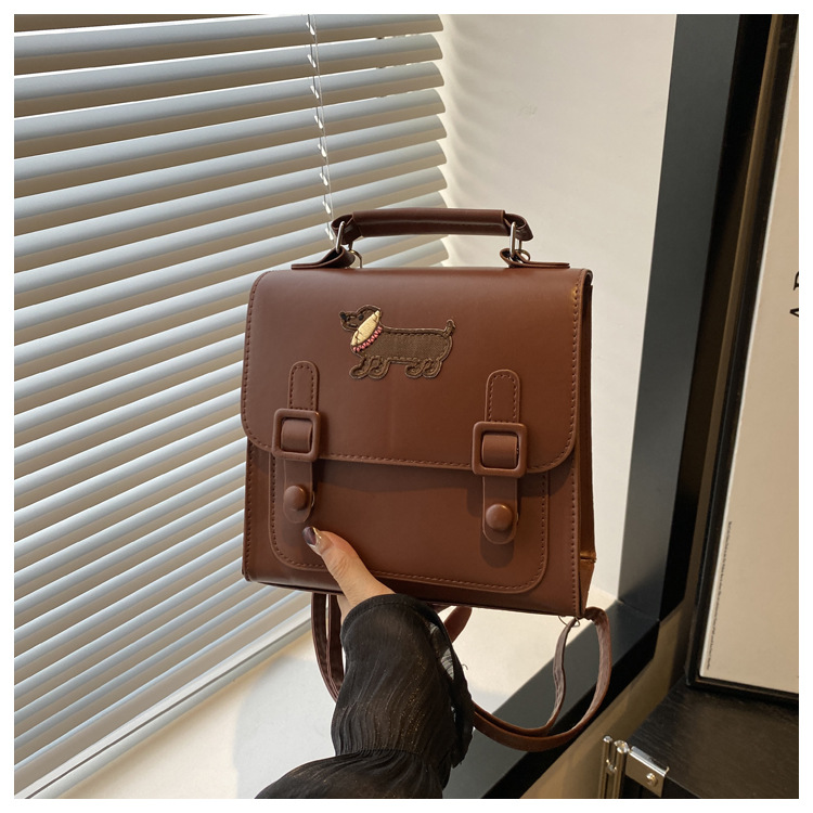 This is a new retro commuting backpack for the autumn of 2024, featuring a casual color contrast and a niche design. It is a small square single-shoulder hand-carry bag undefined