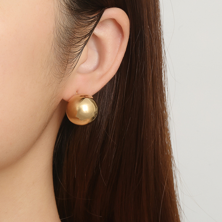 Moda europea y americana alta sensación de aretes huecos de acero inoxidable bolas de lujo ligero para mujeres chapado 18K orejas de oro al por mayor