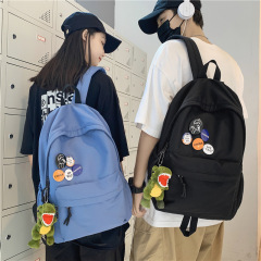 リュックサックの男性のシンプルで軽やかな大容量のリュックサックの日本の中学高校の大学生のカバンの女性はバッジを送ります。