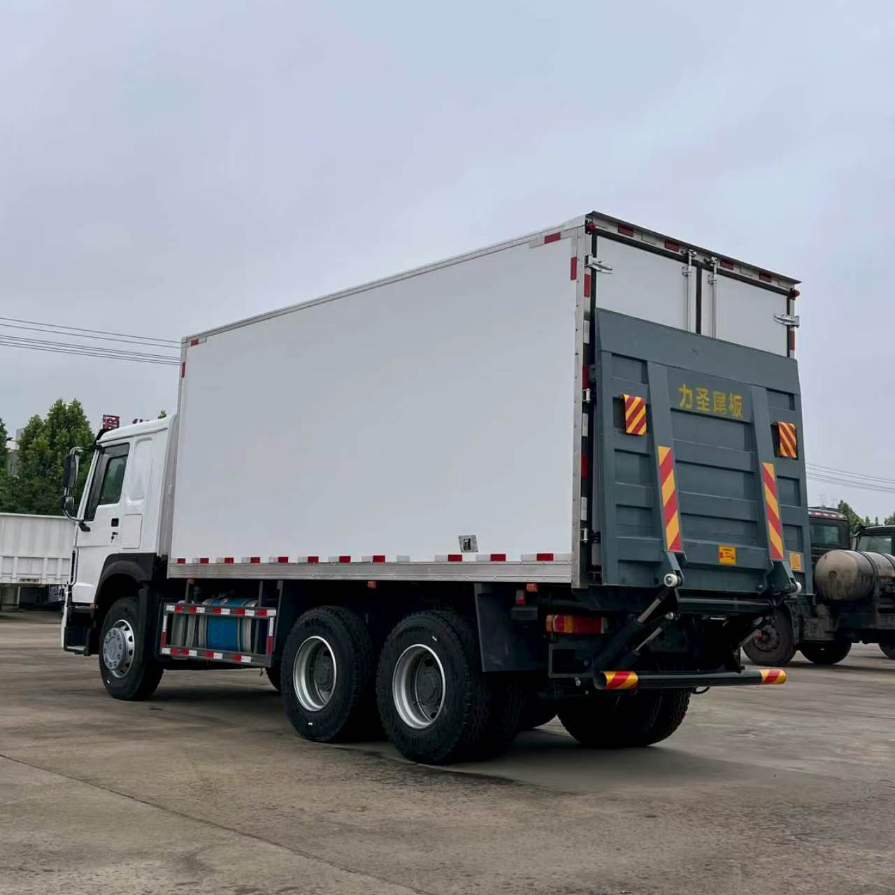 Two Howo self-loading heavy-duty trucks for transporting construction waste and soil, available in stock for direct export, wholesale purchase, and high-quality selection from manufacturers