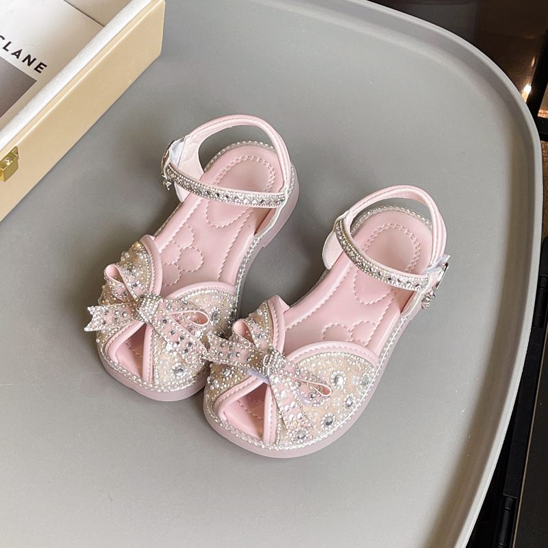 Sandalias Baotou para niñas 2025 verano nuevo estilo bowknot moda cristal princesa zapatos de playa para niños de suela suave marea