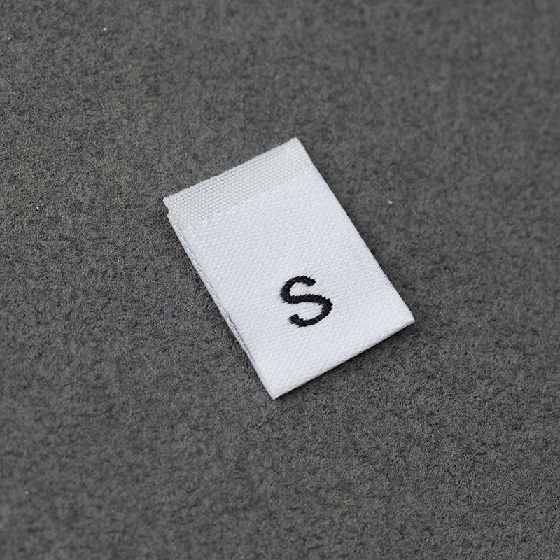 En stock Etiqueta de tamaño de alta densidad en blanco y negro Etiqueta de tamaño universal Etiqueta de código de letra inglesa Pantalones Etiqueta de código de cuello de camiseta