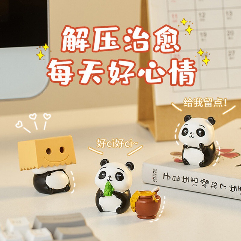 パンダのパソコンは腹ばいになってオフィスのデスクトップの装飾品を飾っています。|undefined